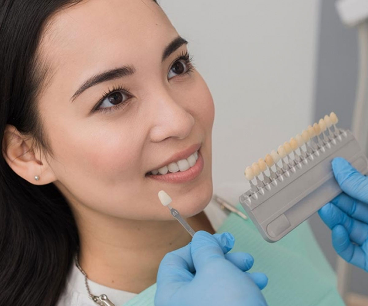 Mujer comparando en clínica dental distintos tipos de coronas dentales